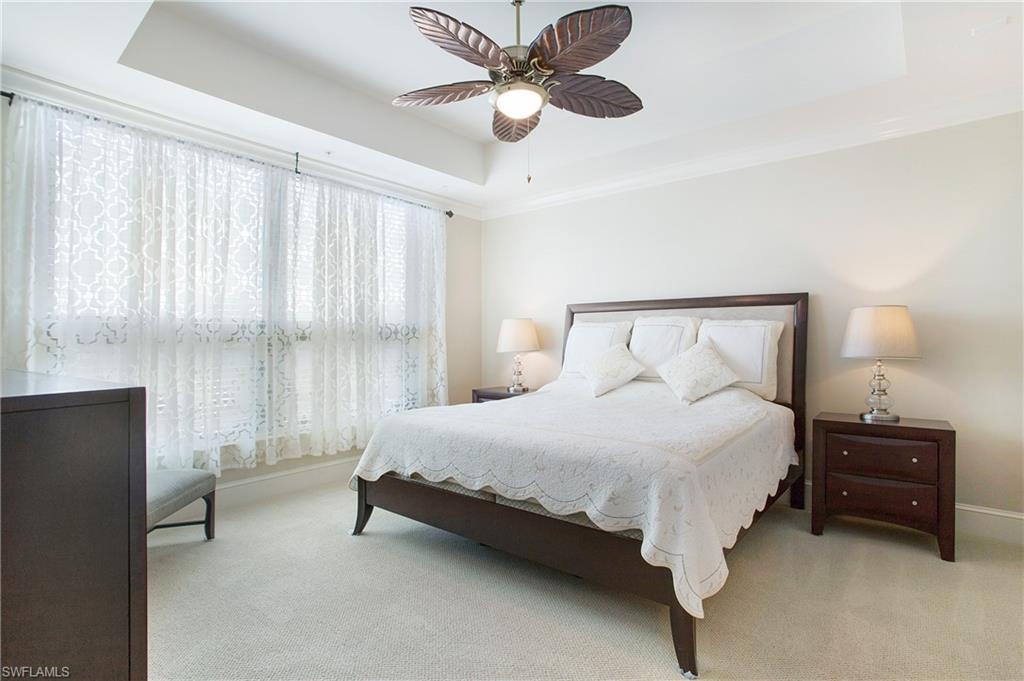 9123 Strada Place, Unit 7307 Naples, FL 34108 - Photo 21 of 49 a bedroom with a bed and a ceiling fan