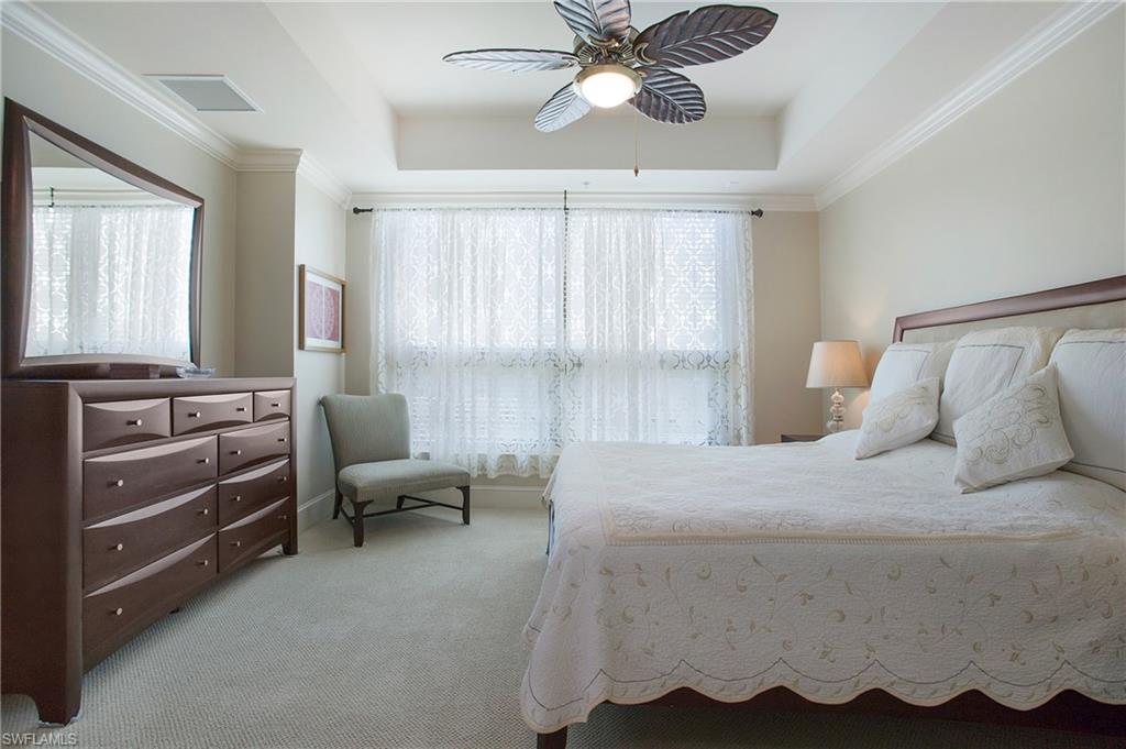9123 Strada Place, Unit 7307 Naples, FL 34108 - Photo 23 of 49 a bedroom with a bed and a chandelier