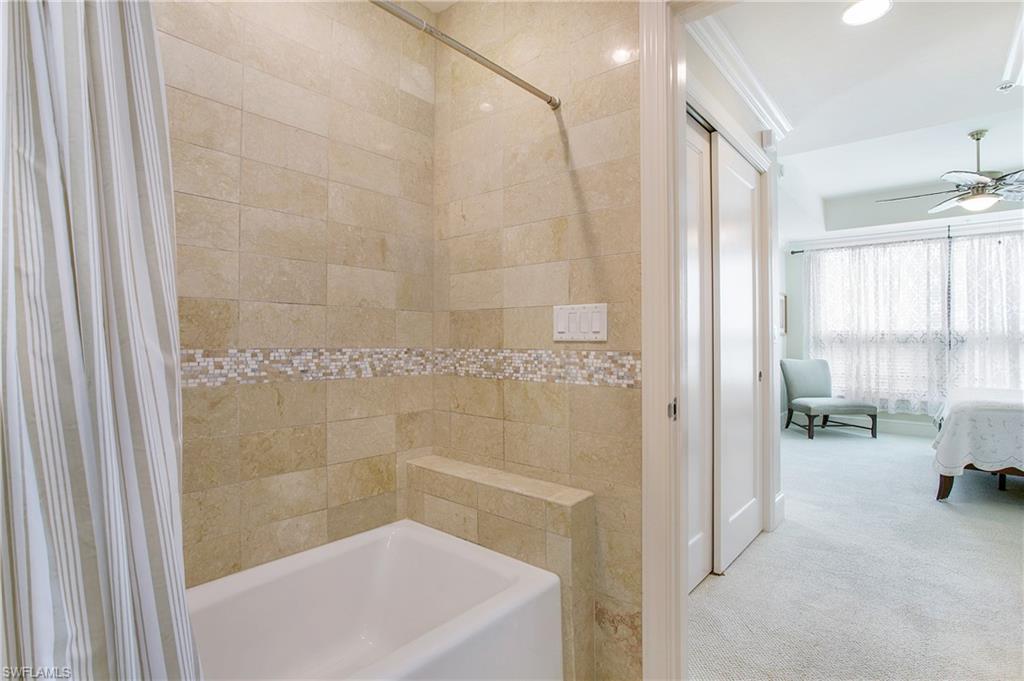 9123 Strada Place, Unit 7307 Naples, FL 34108 - Photo 26 of 49 a bathroom with a tub a window and a shower