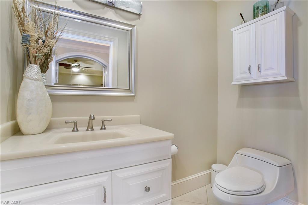 9123 Strada Place, Unit 7307 Naples, FL 34108 - Photo 30 of 49 a bathroom with a toilet a sink and mirror