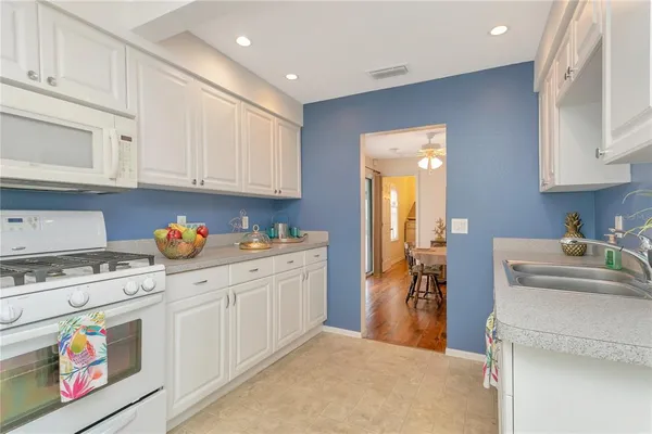 a kitchen with granite countertop a sink a stove and cabinets
