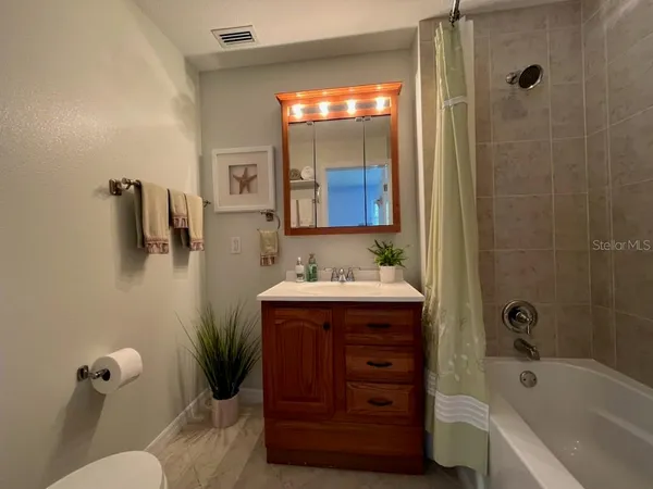 a bathroom with a tub sink and mirror