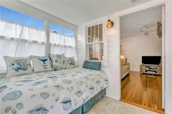 a bedroom with a large bed and a flat tv screen on dresser