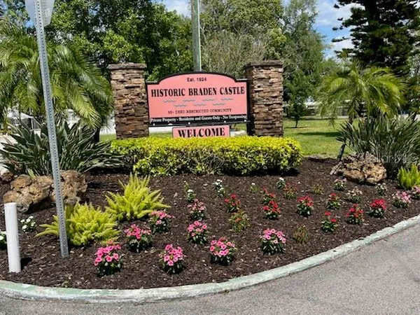 a sign that is sitting in front of flowers