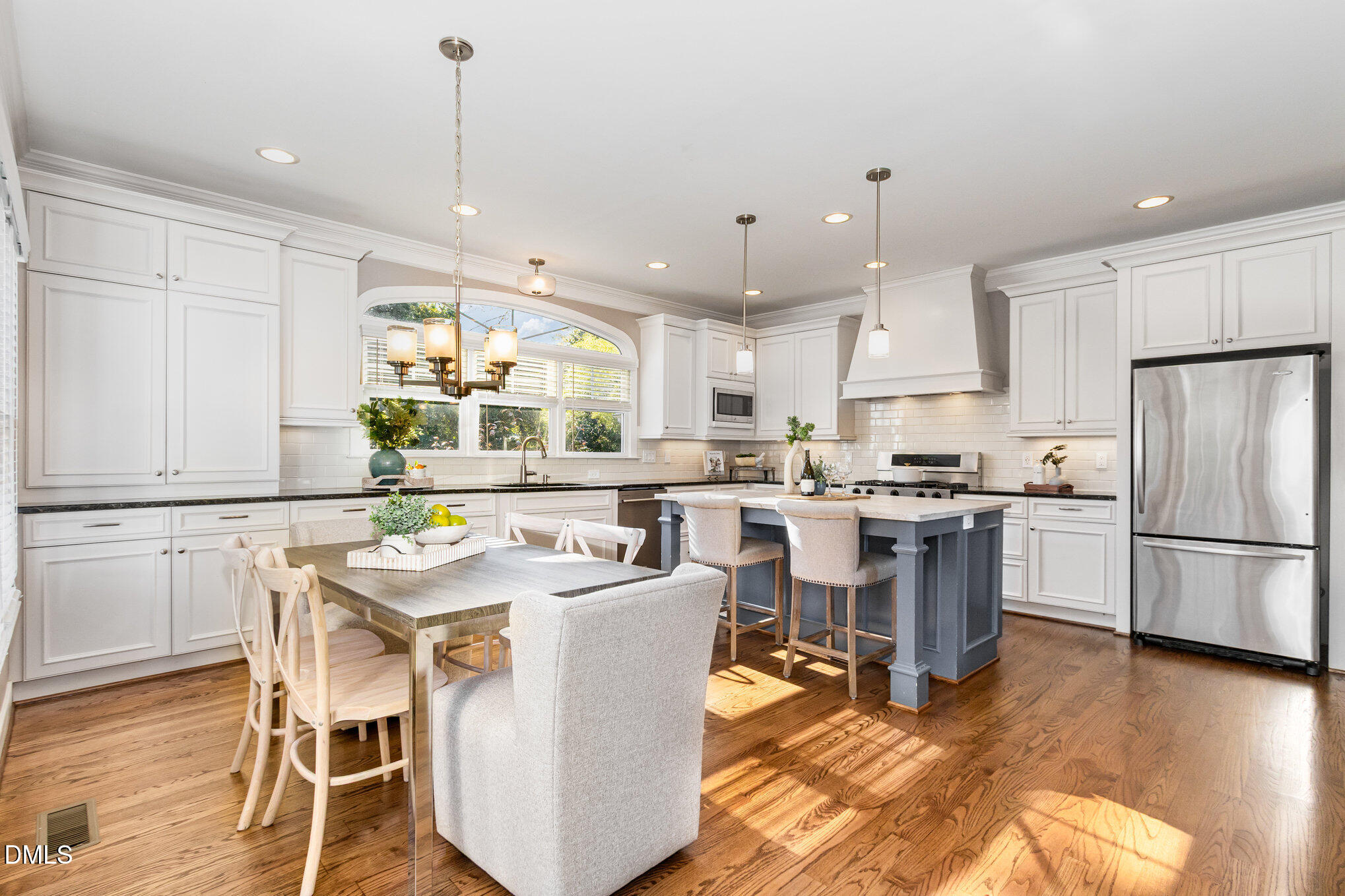 1340 Courtland Drive Raleigh, NC 27604 - Photo 14 of 42 a kitchen with stainless steel appliances kitchen island wooden floors and white cabinets