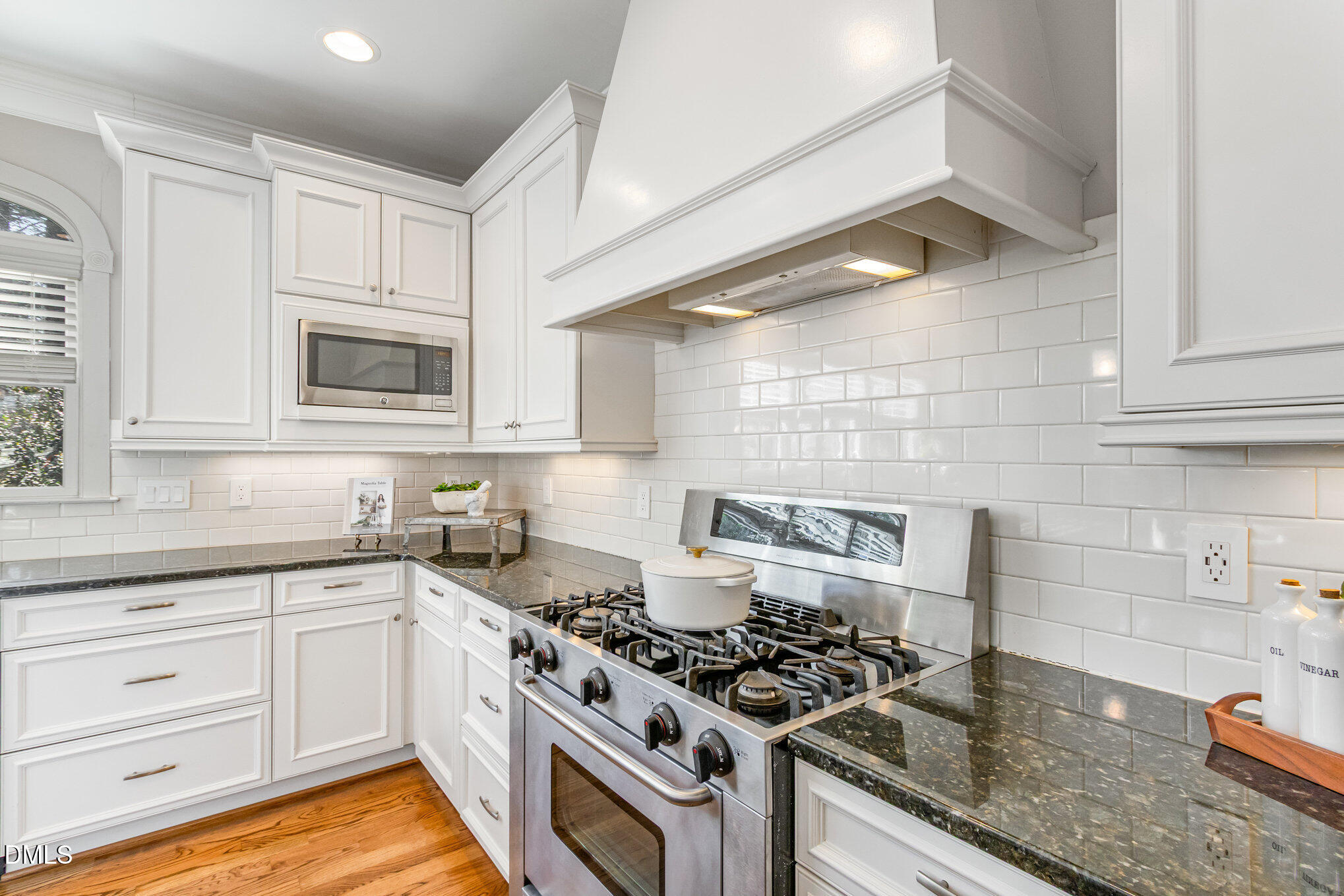 1340 Courtland Drive Raleigh, NC 27604 - Photo 17 of 42 a kitchen with white cabinets and appliances
