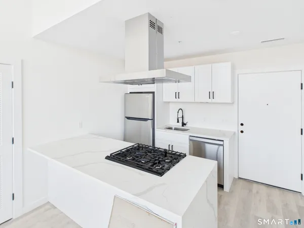 a kitchen with a stove and white cabinets