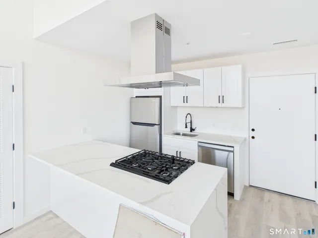 a kitchen with a stove and white cabinets