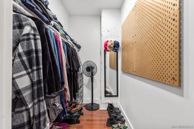 a view of walk in closet with clothes and shoes