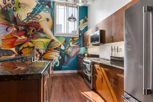 a kitchen with stainless steel appliances granite countertop a stove a sink and a microwave