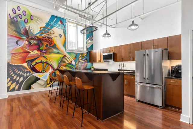 a kitchen with stainless steel appliances granite countertop a refrigerator a stove and a wooden floor