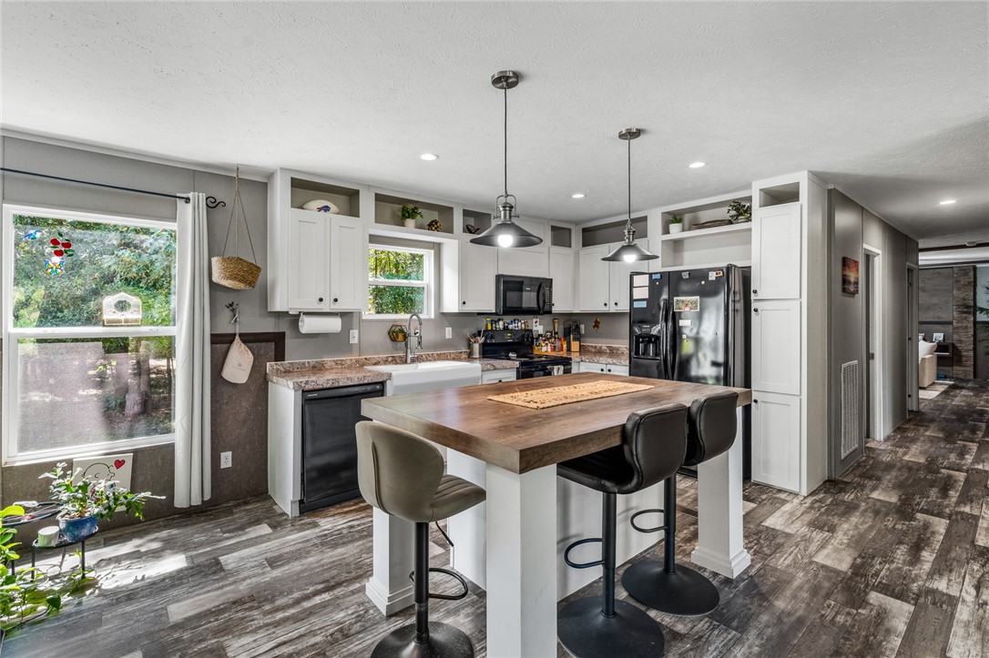 Rich wood plank floors complement the warm block island and clean cabinetry of this kitchen.
