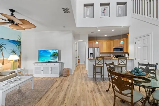 a living room with furniture a flat screen tv and kitchen view