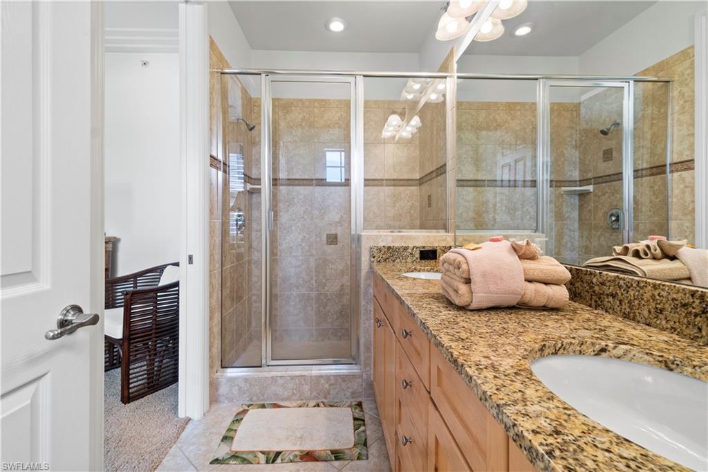 9111 Capistrano Street South, Unit 8303 Naples, FL 34113 - Photo 11 of 29 a bathroom with a granite countertop sink and a shower