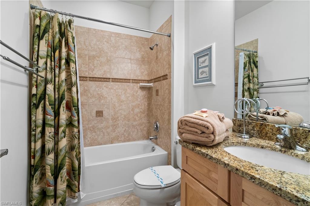 9111 Capistrano Street South, Unit 8303 Naples, FL 34113 - Photo 13 of 29 a bathroom with a granite countertop sink toilet and shower