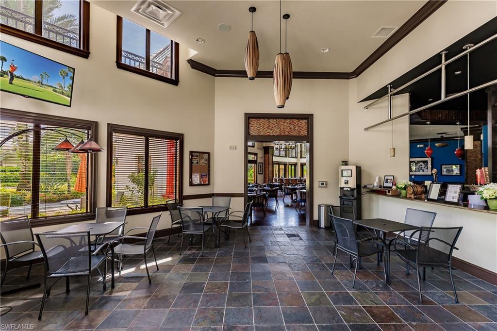 9111 Capistrano Street South, Unit 8303 Naples, FL 34113 - Photo 23 of 29 a room with lots of tables a large window and chairs