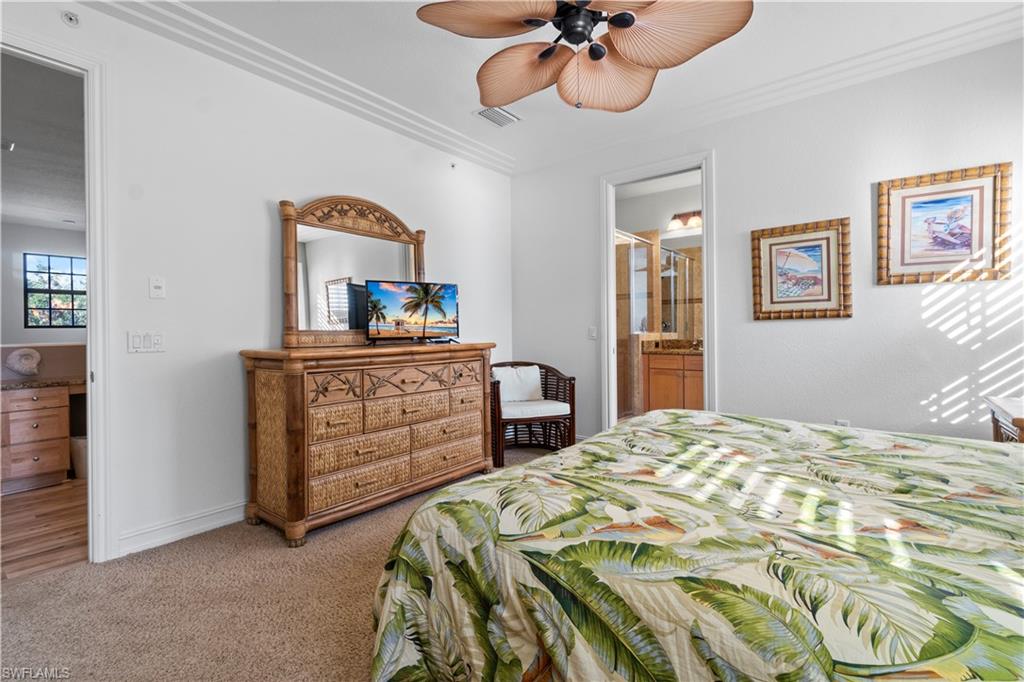 9111 Capistrano Street South, Unit 8303 Naples, FL 34113 - Photo 10 of 29 a bedroom with a bed and a chandelier
