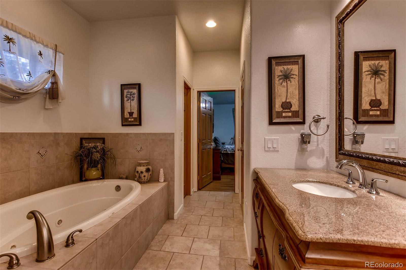 691 Picadilly Road Aurora, CO 80018 - Photo 18 of 27 a bathroom with a tub a sink and a mirror