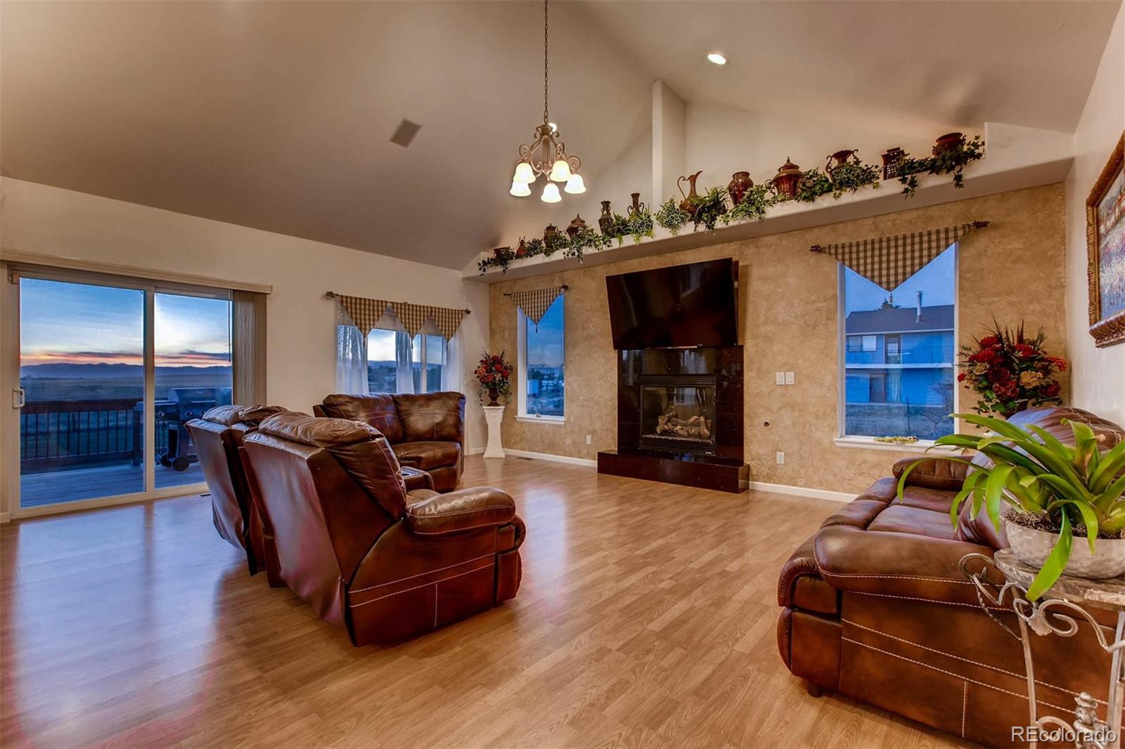 691 Picadilly Road Aurora, CO 80018 - Photo 3 of 27 a living room with furniture a flat screen tv and a fireplace