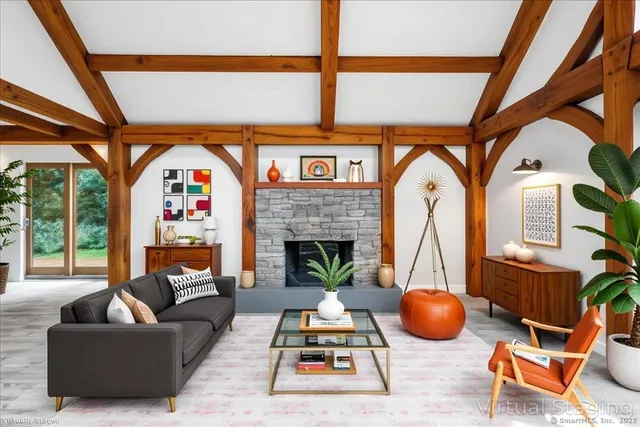 a living room with furniture a fireplace and a floor to ceiling window