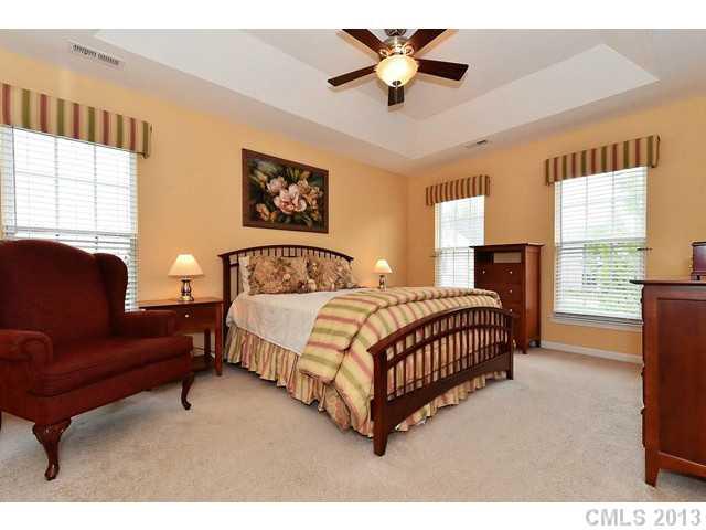729 Warwick Way Fort Mill, SC 29708 - Photo 8 of 16 a spacious bedroom with a bed painting on wall and windows