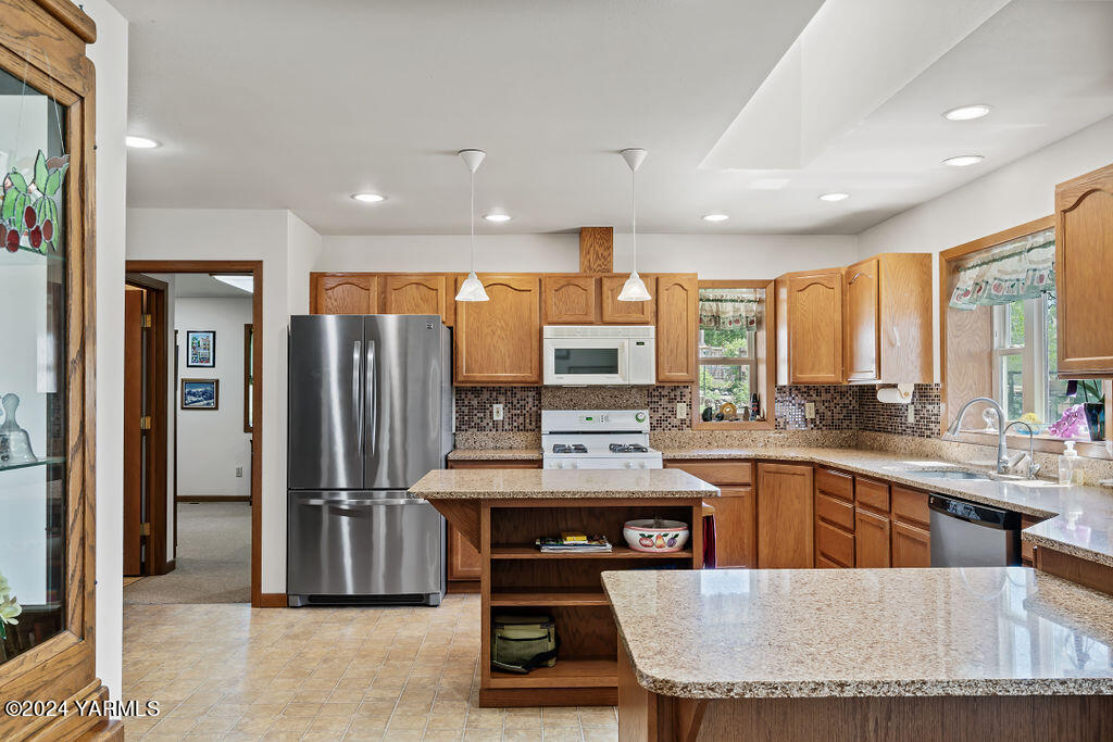 1241 Nelson Road Granger, WA 98932 - Photo 10 of 45 a kitchen with stainless steel appliances granite countertop a stove top oven a refrigerator a sink and dining table