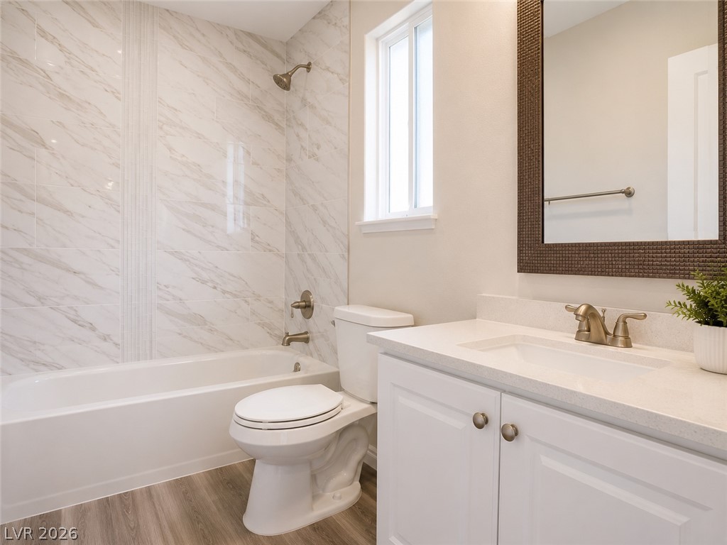 200 East Gamebird Road Pahrump, NV 89048 - Photo 17 of 23 A well-lit bathroom showcases elegant marble-patterned tile and a sleek vanity with modern fixtures.