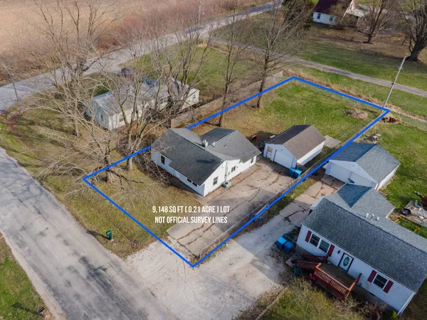 a backyard of a house with large trees and wooden fence