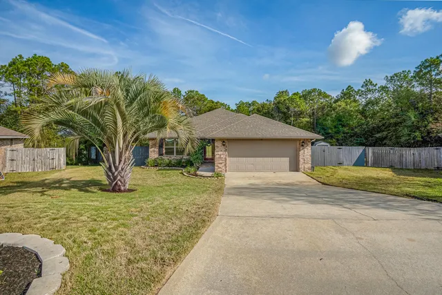 a view of a house with backyard and a tree