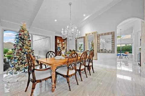 a living room with furniture kitchen view and a chandelier