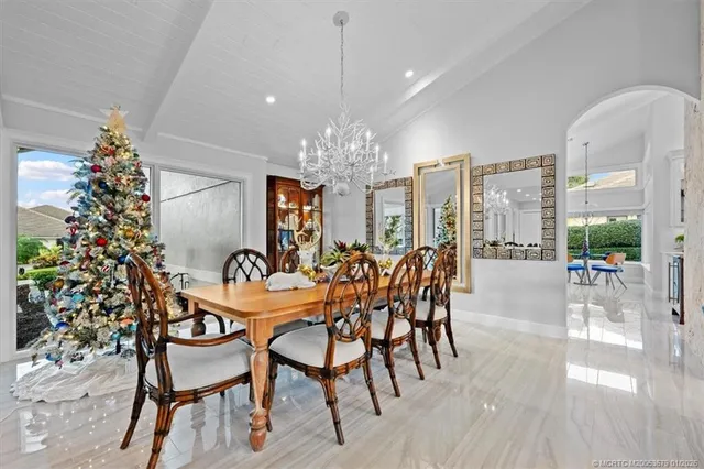 a living room with furniture kitchen view and a chandelier