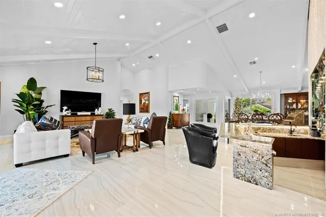a kitchen with stainless steel appliances kitchen island granite countertop a stove and a view of living room