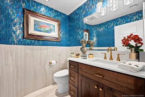 a bathroom with a granite countertop sink mirror and toilet
