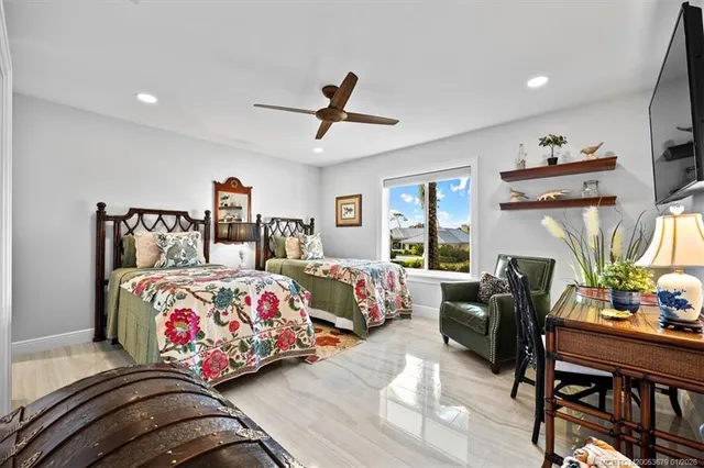 a view of a swimming pool with a lawn chairs and palm trees