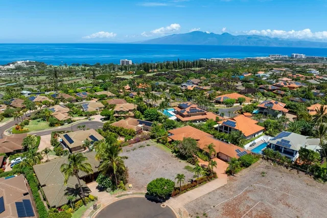 an aerial view of residential houses with outdoor space and ocean view