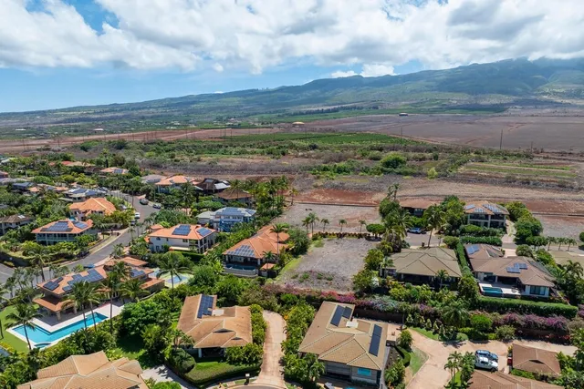 an aerial view of a city with lots of residential buildings and mountain view in back