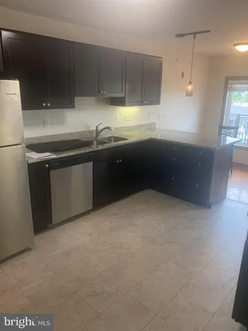 a kitchen with kitchen island a sink stainless steel appliances and cabinets