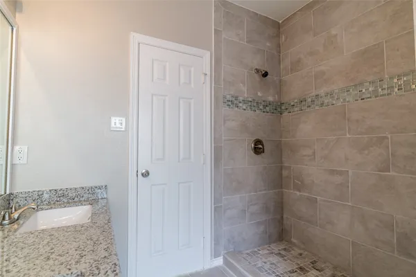 a bathroom with a granite countertop shower