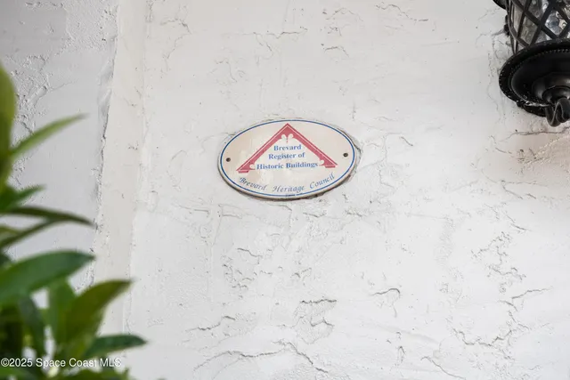 a view of an empty room with wooden floor fireplace and a window