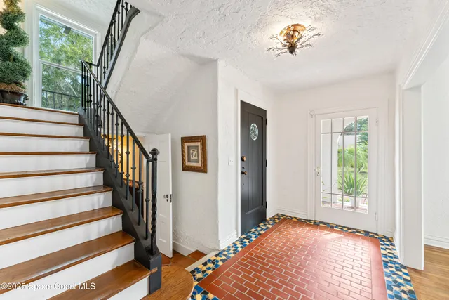 a view of a hallway with wooden floor and stairs