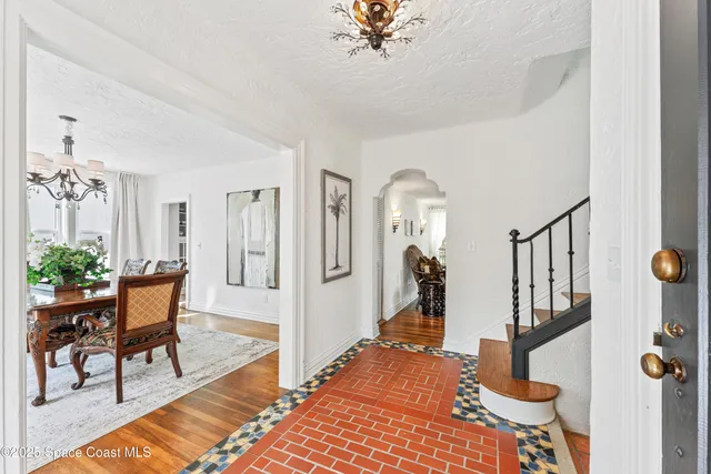a view of a hallway with wooden floor and windows