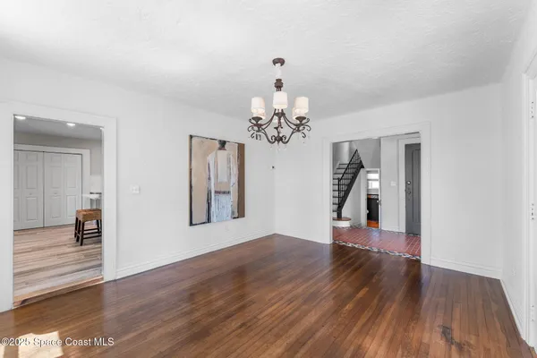 a kitchen with a stove a sink dishwasher a microwave oven with white cabinets and wooden floor