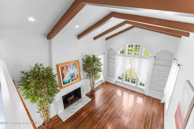 a view of empty room with wooden floor fireplace and window