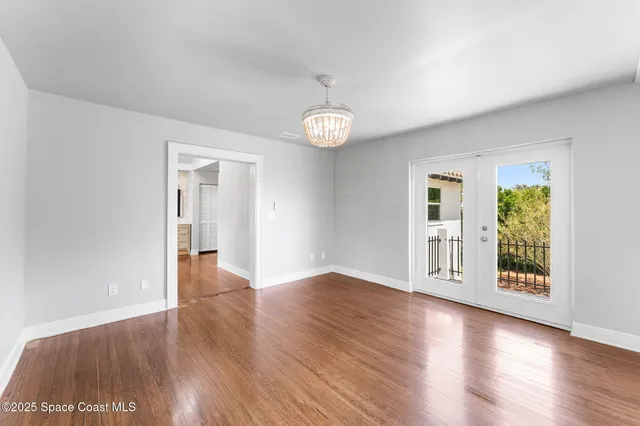 a kitchen with a stove a sink dishwasher a microwave oven with white cabinets and wooden floor