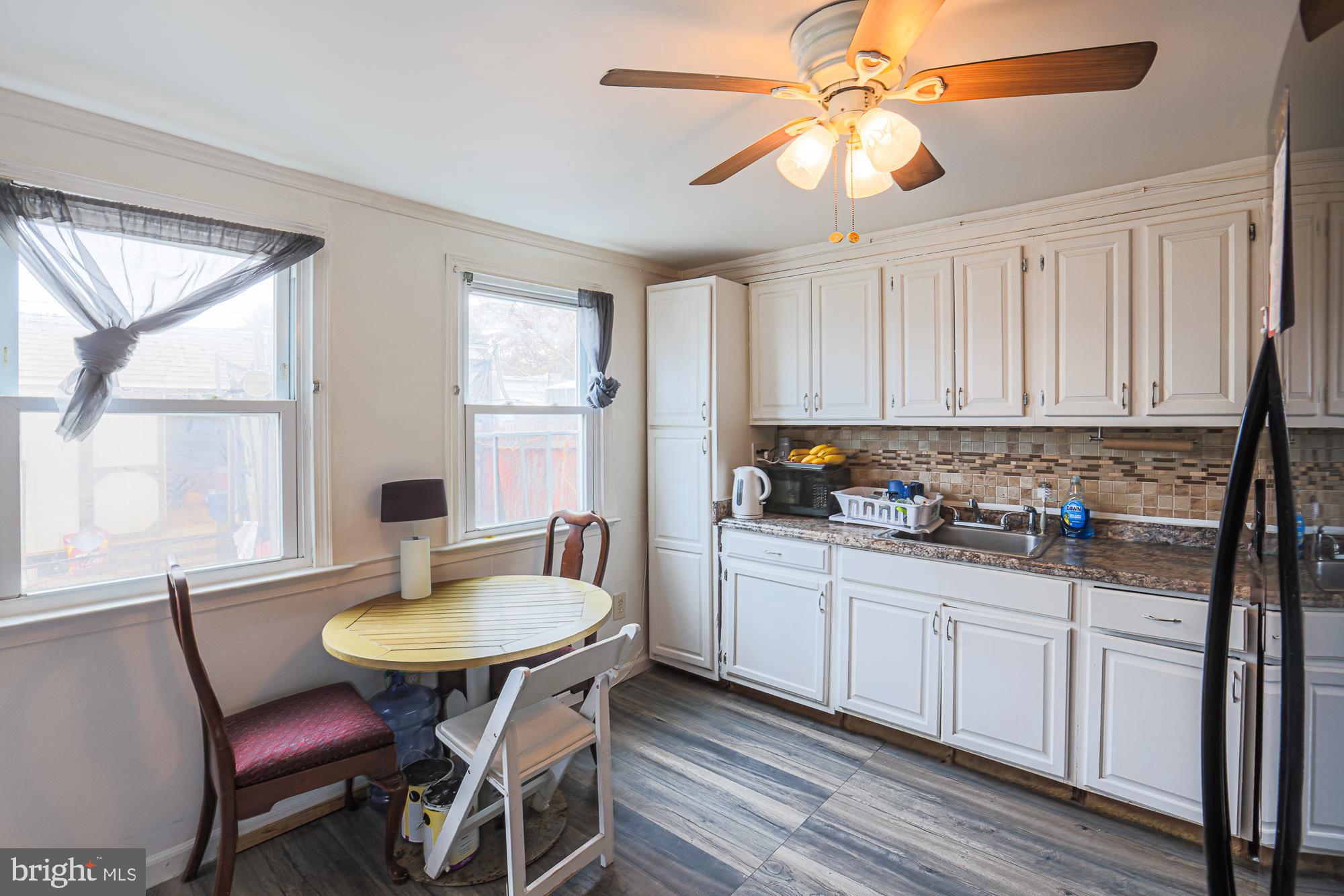 2707 Norfen Road Baltimore, MD 21227 - Photo 3 of 11 a kitchen with stainless steel appliances a white table chairs and a window
