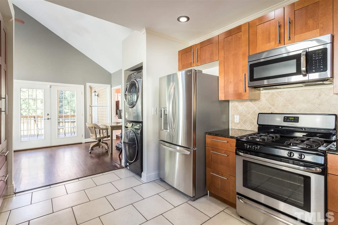 505 Holden Street Raleigh, NC 27604 - Photo 6 of 21 a kitchen with granite countertop a refrigerator and a stove top oven