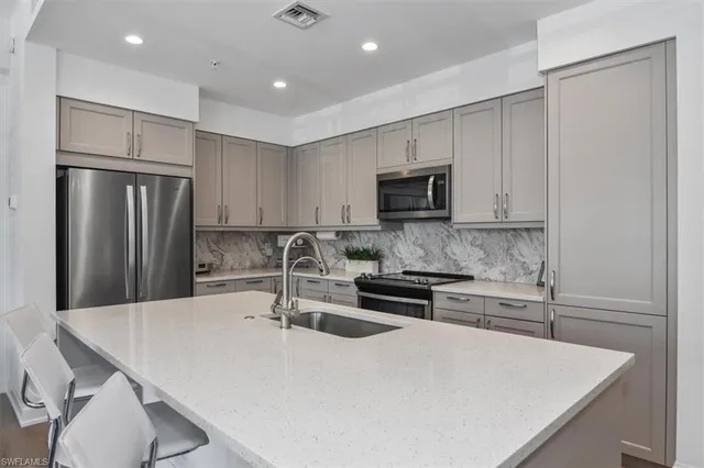 a kitchen with kitchen island a sink stove and refrigerator