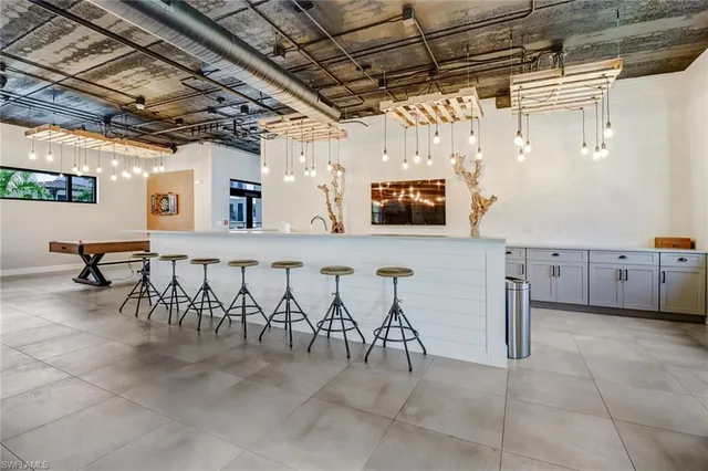 a large white kitchen with stainless steel appliances granite countertop a sink and a microwave