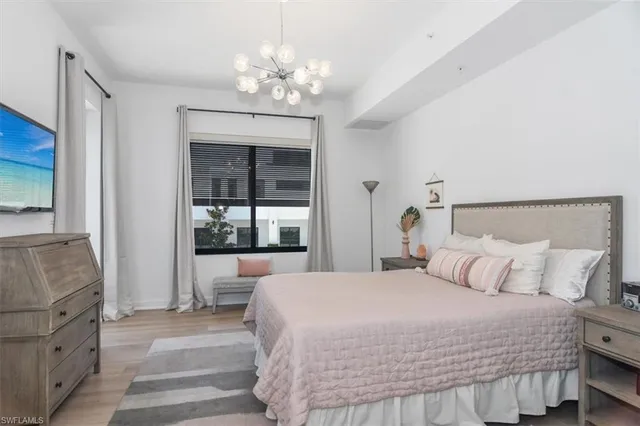 a bedroom with a large bed and a chandelier