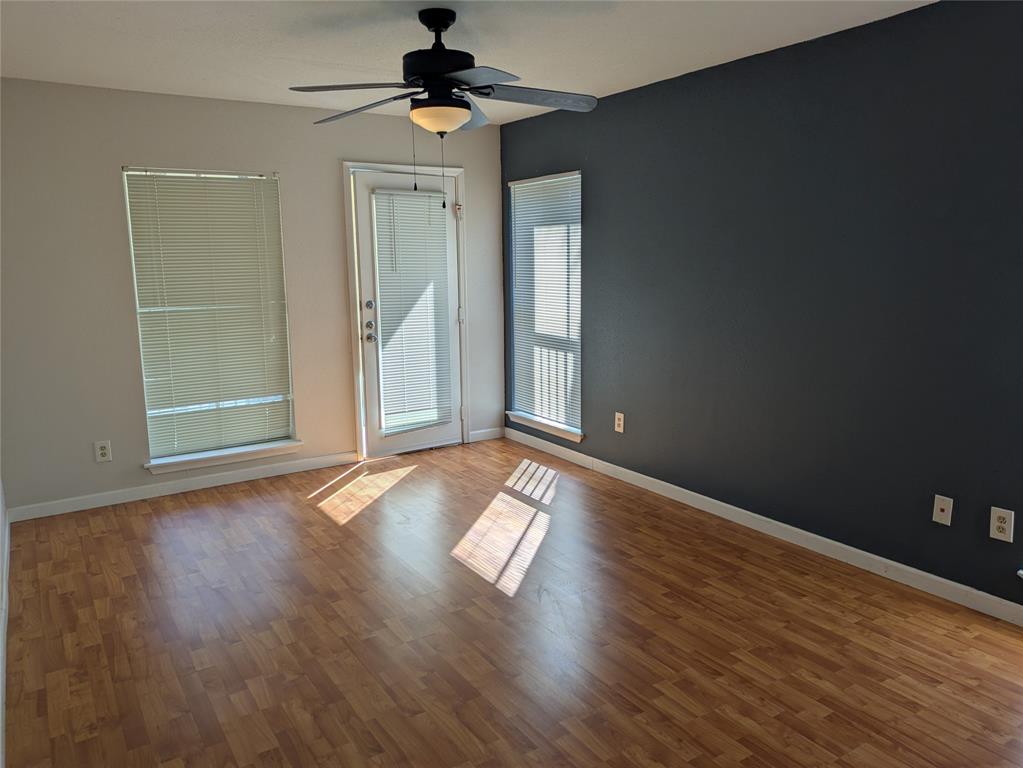 977 Riverside Drive, Unit 226 Coral Springs, FL 33071 - Photo 7 of 13 an empty room with wooden floor a ceiling fan and windows